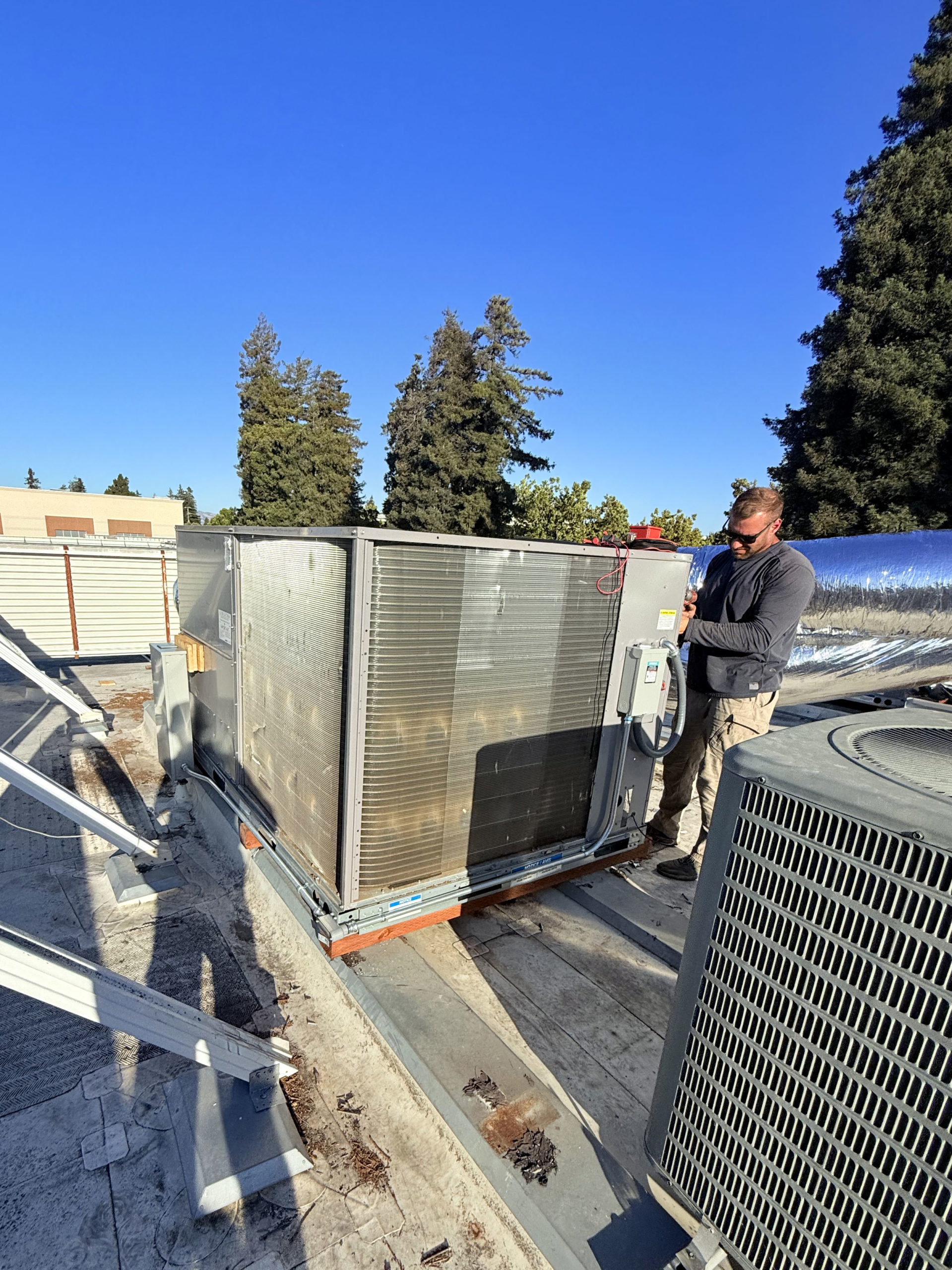 Technician working on rooftop HVAC equipment
